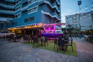 un ristorante con tavoli e sedie di fronte a un edificio di Sawasdee Siam Pattaya Hotel a Centro di Pattaya
