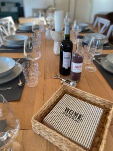 una mesa de madera con 2 botellas de vino y copas en Sumptuous Cap Ferret Style House, en La Teste-de-Buch