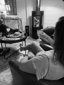 una mujer sentada en un sofá con una copa de vino en Sumptuous Cap Ferret Style House, en La Teste-de-Buch