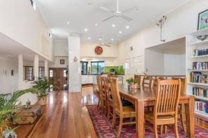 uma cozinha e sala de jantar com uma mesa de madeira e cadeiras em Angel's Beach Hidden Oasis em East Ballina