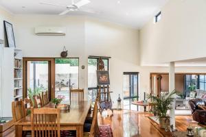 a living room with a wooden table and chairs at Angel's Beach Hidden Oasis in East Ballina