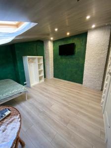 Міні готель на Костюринському في خاركوف: غرفة معيشة بجدران خضراء وأرضية خشبية