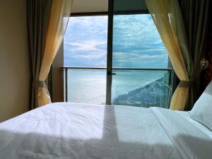 łóżko w pokoju z dużym oknem w obiekcie Copacabana Jomtien Beach Condo 中天海滩寇芭酒店公寓 w mieście Jomtien Beach