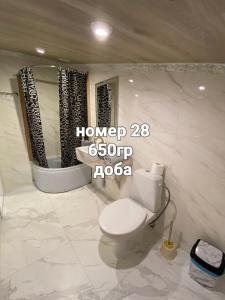 a bathroom with a toilet and a sink and a mirror at Міні готель на Костюринському in Kharkiv