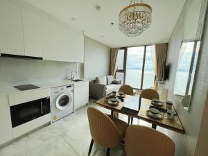 uma cozinha e sala de estar com uma mesa e uma máquina de lavar roupa em Copacabana Jomtien Beach Condo 中天海滩寇芭酒店公寓 em Praia de Jomtien