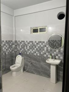 bagno con servizi igienici, lavandino e specchio di Deka’s Homestay a Tezpur