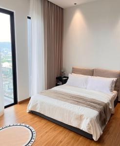 um quarto com uma cama grande e uma janela grande em Beacon Executive@Penang Georgetown em George Town