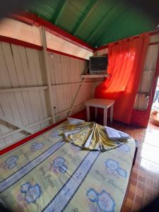 a room with a bed and a tv in it at Cabaña Playa Ladrilleros in Playa Ladrilleros