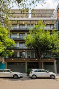 two cars parked in front of a building at Choapan 28 - Lux Apartments in Condesa in Mexico City