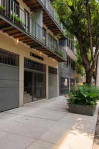 a building with two garage doors and a tree at Choapan 28 - Lux Apartments in Condesa in Mexico City