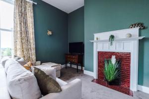 a living room with a couch and a fireplace at 1B Victorian Retreat in Chester in Chester