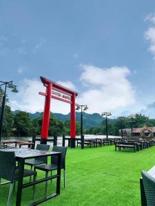 a picnic area with tables and chairs and a sign at SAIYOK MANTRA RESORT : ไทรโยค มันตรา รีสอร์ท in Ban Huai Maenam Noi