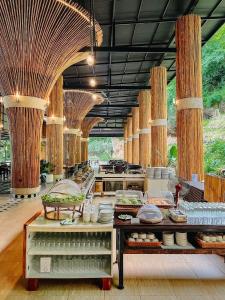 a large kitchen with a counter with food on it at SAIYOK MANTRA RESORT : ไทรโยค มันตรา รีสอร์ท in Ban Huai Maenam Noi