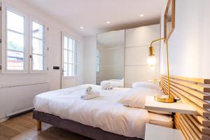 a bedroom with a large white bed with a desk at 403 · Wonder Appart' - Vue sur Garonne - in Toulouse