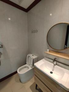 a bathroom with a toilet and a sink and a mirror at Casa Casa in Semporna