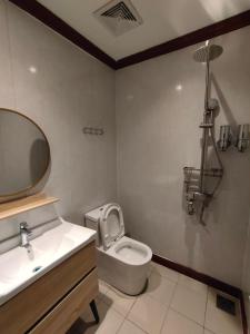 a bathroom with a toilet and a sink and a mirror at Casa Casa in Semporna