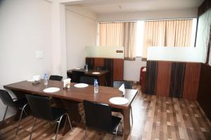a conference room with a large wooden table and chairs at Orange Corner Hotel, MONTHLY STAY AVAILABLE in Yelahanka