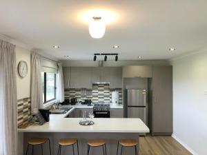 a kitchen with a large white island in the middle at Tranquil, modern self-contained cottage in Scarsdale