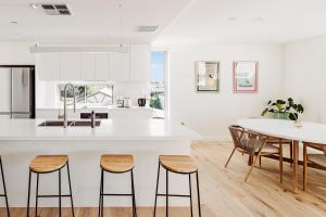 a kitchen and dining room with a table and chairs at SILK - Lustrous Vacation Awaits 400m to the Beach in Coolum Beach