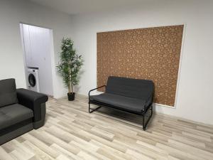 a waiting room with a couch and a chair at Grove Apartment in Buzău