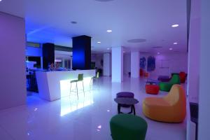 uma sala de estar com cadeiras coloridas e um bar em Giulivo Hotel & Village em Baia Domizia