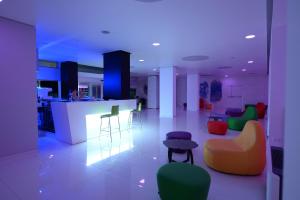 una sala de estar con sillas coloridas y un bar en Giulivo Hotel & Village, en Baia Domizia