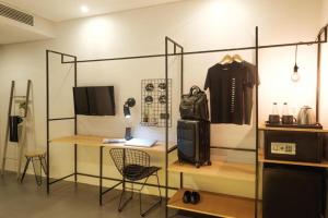 a room with a desk and a shirt hanging on a wall at The Hammock Hotel Ben Thanh in Ho Chi Minh City