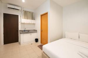 - une petite chambre avec un lit et un lavabo dans l'établissement JP Santiago Studio Makati J303, à Manille