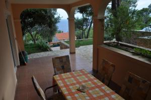 a table and chairs on a porch with a view of the ocean at Apartmani Anja in Sveta Nedelja