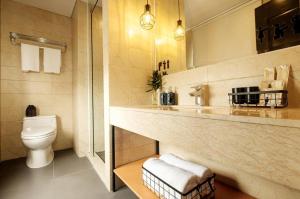 a bathroom with a toilet and a sink at The Hammock Hotel Ben Thanh in Ho Chi Minh City