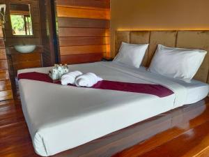 a large white bed with towels on it at SAIYOK MANTRA RESORT : ไทรโยค มันตรา รีสอร์ท in Ban Huai Maenam Noi
