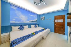 ein blaues Schlafzimmer mit einem großen Bett mit blauen Wänden in der Unterkunft Jinduo Family Homestay in Wujie