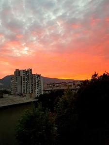 una puesta de sol sobre una ciudad con edificios y árboles en Apartman Nira en Zenica