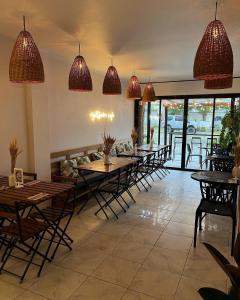 una sala da pranzo con tavoli, sedie e luci a ciondolo di Balayong Pension a Città di Puerto Princesa