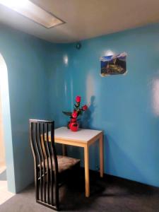 une table avec une chaise et un vase de fleurs dans l'établissement Flying House Hostel, à Arequipa