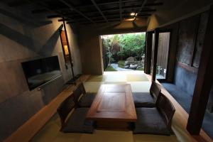 a dining room with a wooden table and chairs at Zen Machiya Private Residence near Heian Shrine in Kyoto