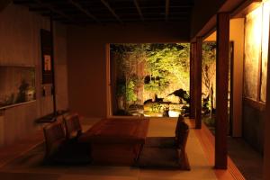 une salle à manger avec un grand aquarium en arrière-plan dans l'établissement Zen Machiya Inn, à Kyoto