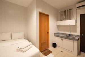 Cette petite chambre comprend un lit et un lavabo. dans l'établissement JP Santiago Studio Makati J304, à Manille