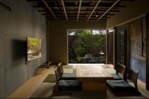 a dining room with a table and chairs and a window at Zen Machiya Private Residence near Heian Shrine in Kyoto