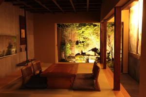 Un comedor con una mesa y un gran ventanal. en Zen Machiya Inn, en Kioto