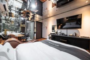 um quarto de hotel com uma cama e uma área de refeições em You&Me Hotel em Seongnam