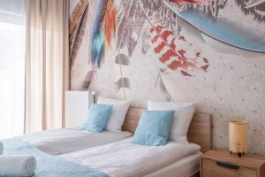 1 dormitorio con 1 cama con almohadas azules y blancas en RentPlanet - Nowa Manufaktura, en Wroclaw