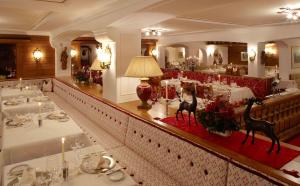 a restaurant with a long counter with tables in it at Sporthotel Lorünser in Zürs am Arlberg