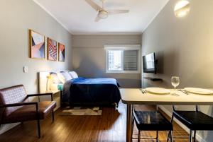 a bedroom with a bed and a table and chairs at Castelli Studios centro SP in Sao Paulo