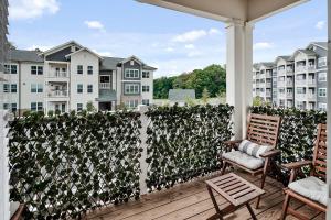a patio with two chairs and a privacy fence at South Asheville Getaway Private Balcony Apt 1 in Arden