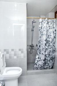 a bathroom with a shower curtain with a toilet at The Royal Hotel in Samarkand