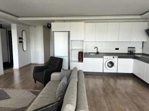 uma sala de estar com um sofá e uma máquina de lavar roupa em Luxury Apartment with Garden right by sea em Mudanya