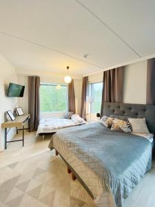 a bedroom with a large bed and a desk at BOSSHOMES Apartments Espoo - Close to Helsinki and access to Airport in Espoo