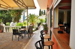 un patio al aire libre con sillas y mesas y un bar en Hotel Pyrros, en Kontokali