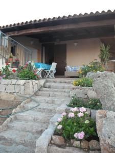 un giardino con alcuni fiori e alcune rocce di Casa Vacanze Il Pino a Cannigione